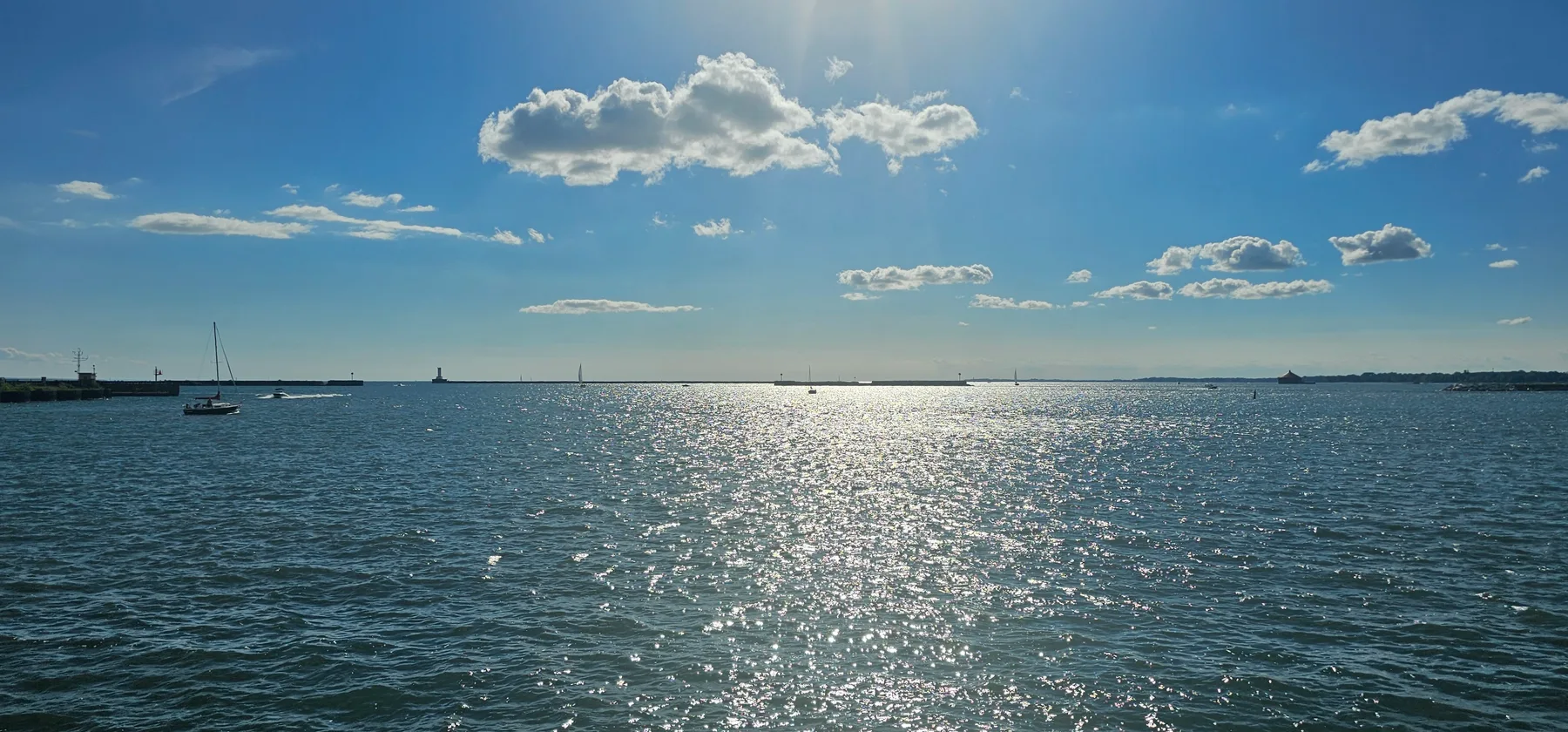 Sunlight sparkling across Lake Erie, with boats on the horizon.